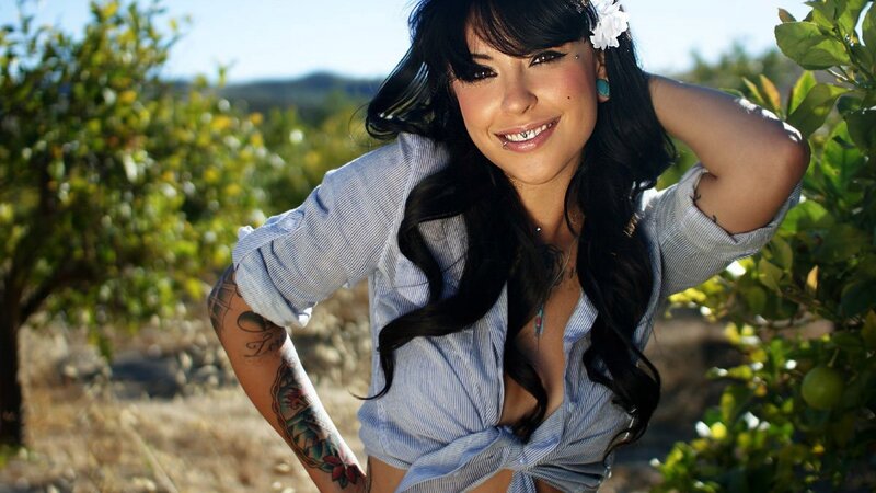 woman with tattoos in orchard