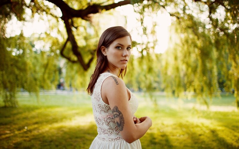 woman with tattoos in park