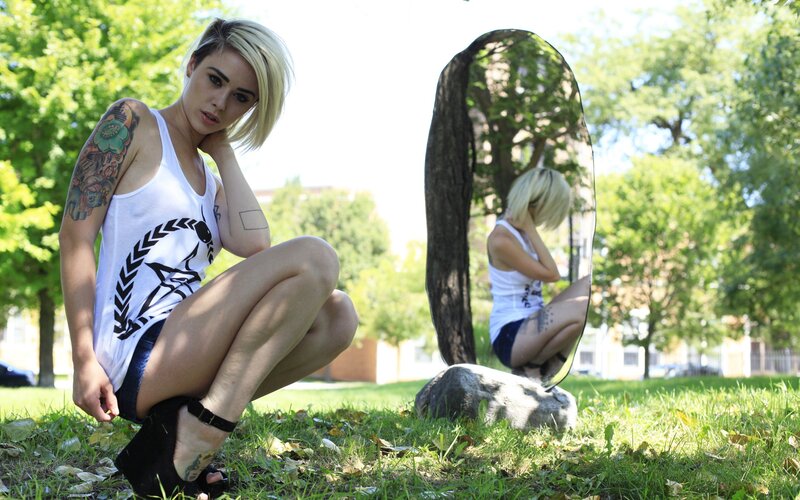 Woman with tattoos in park