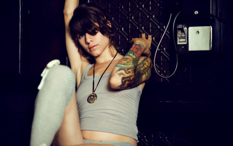 woman with tattoos in phone booth