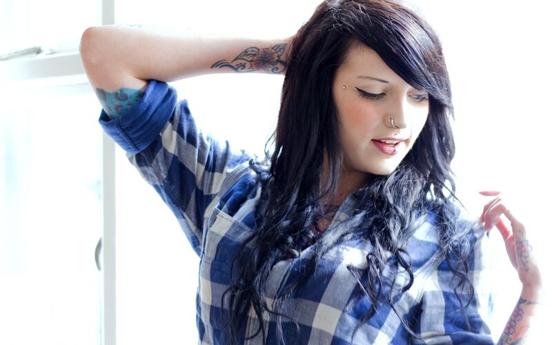 woman with tattoos in plaid shirt