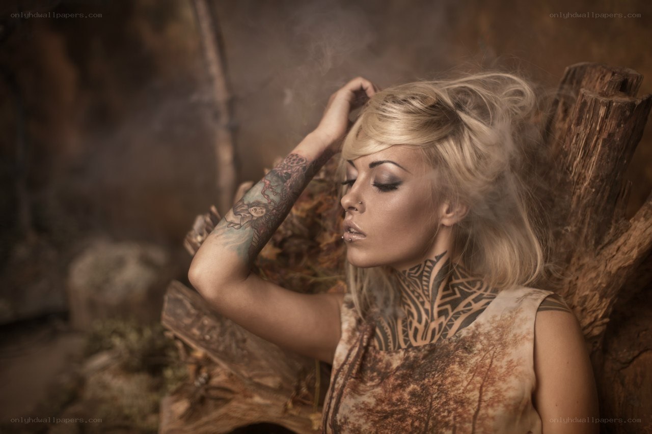 woman with tattoos in rustic setting