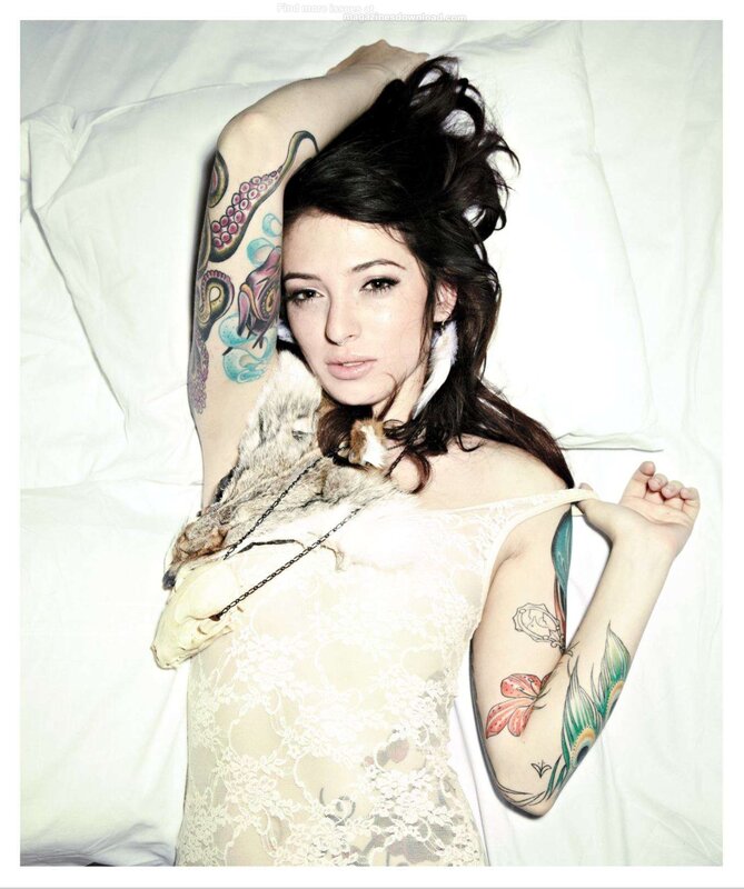 woman with tattoos lying on bed