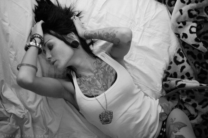 woman with tattoos lying on bed