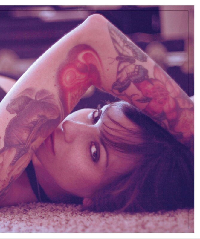 woman with tattoos lying on floor