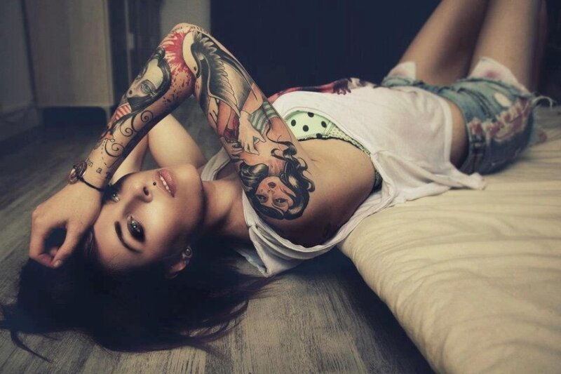 woman with tattoos lying on floor