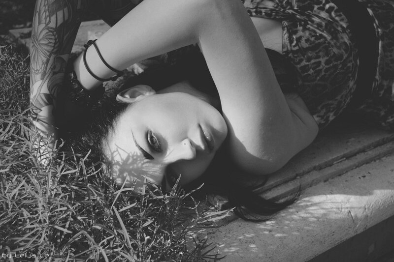 woman with tattoos lying on grass
