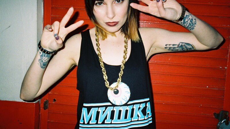 woman with tattoos making peace signs
