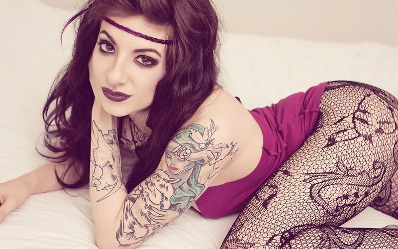 woman with tattoos on bed