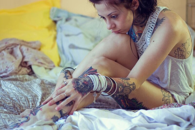 woman with tattoos on bed