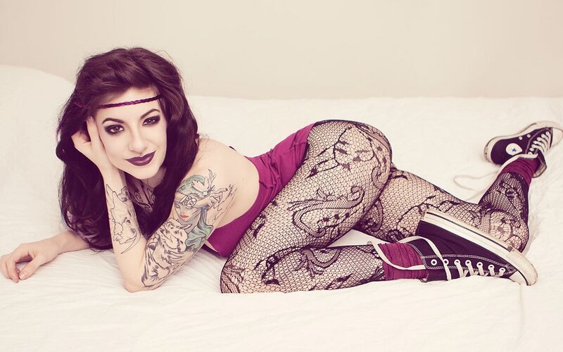 woman with tattoos on bed