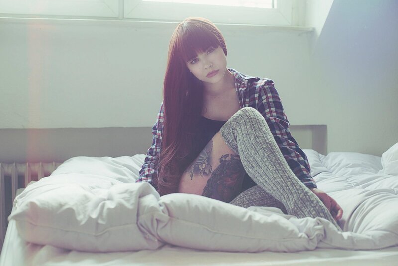woman with tattoos on bed