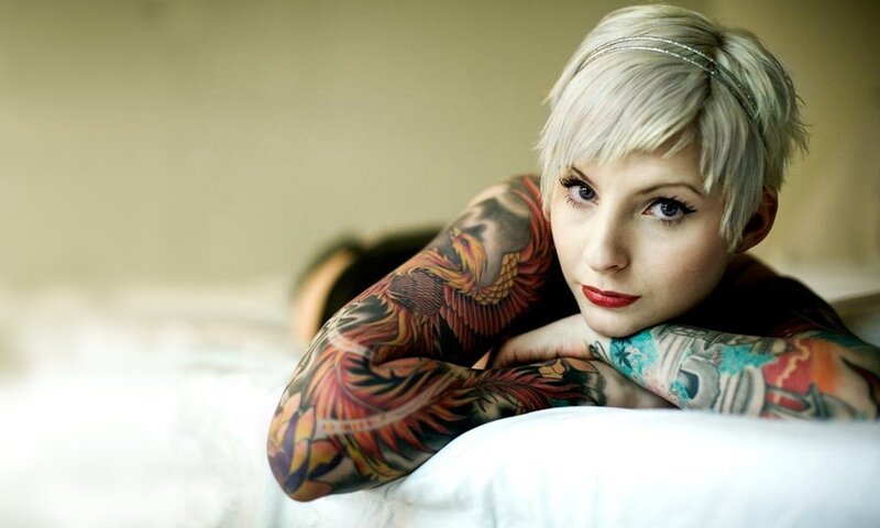 woman with tattoos on bed