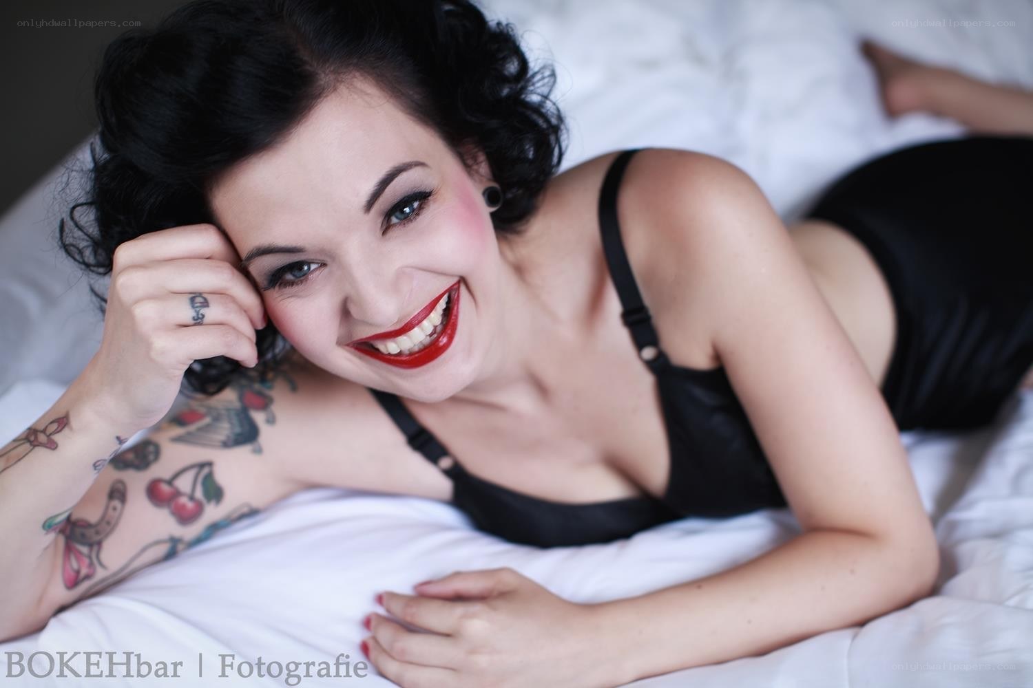 woman with tattoos on bed
