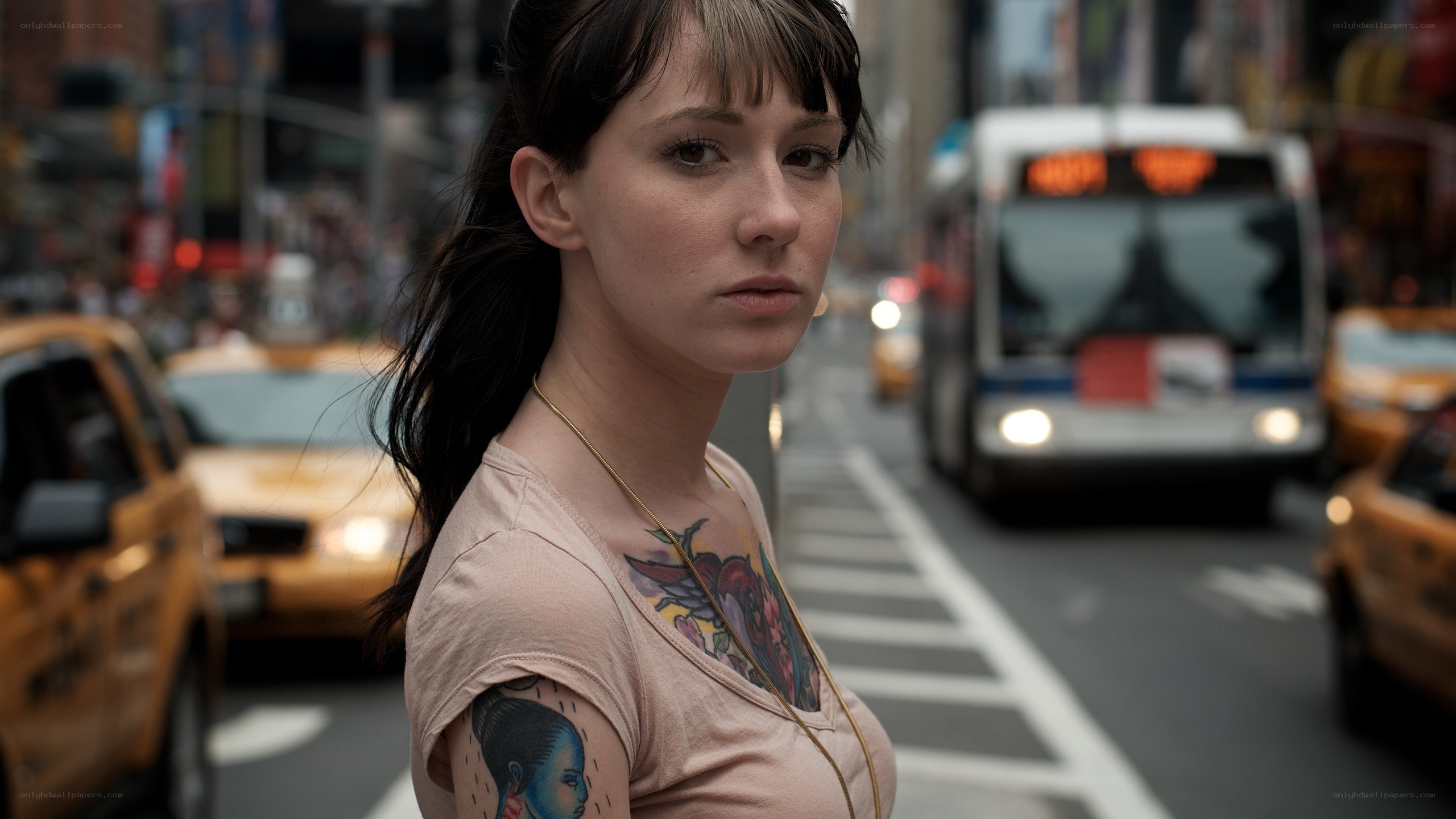 woman with tattoos on city street