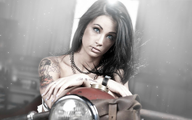 woman with tattoos on motorcycle