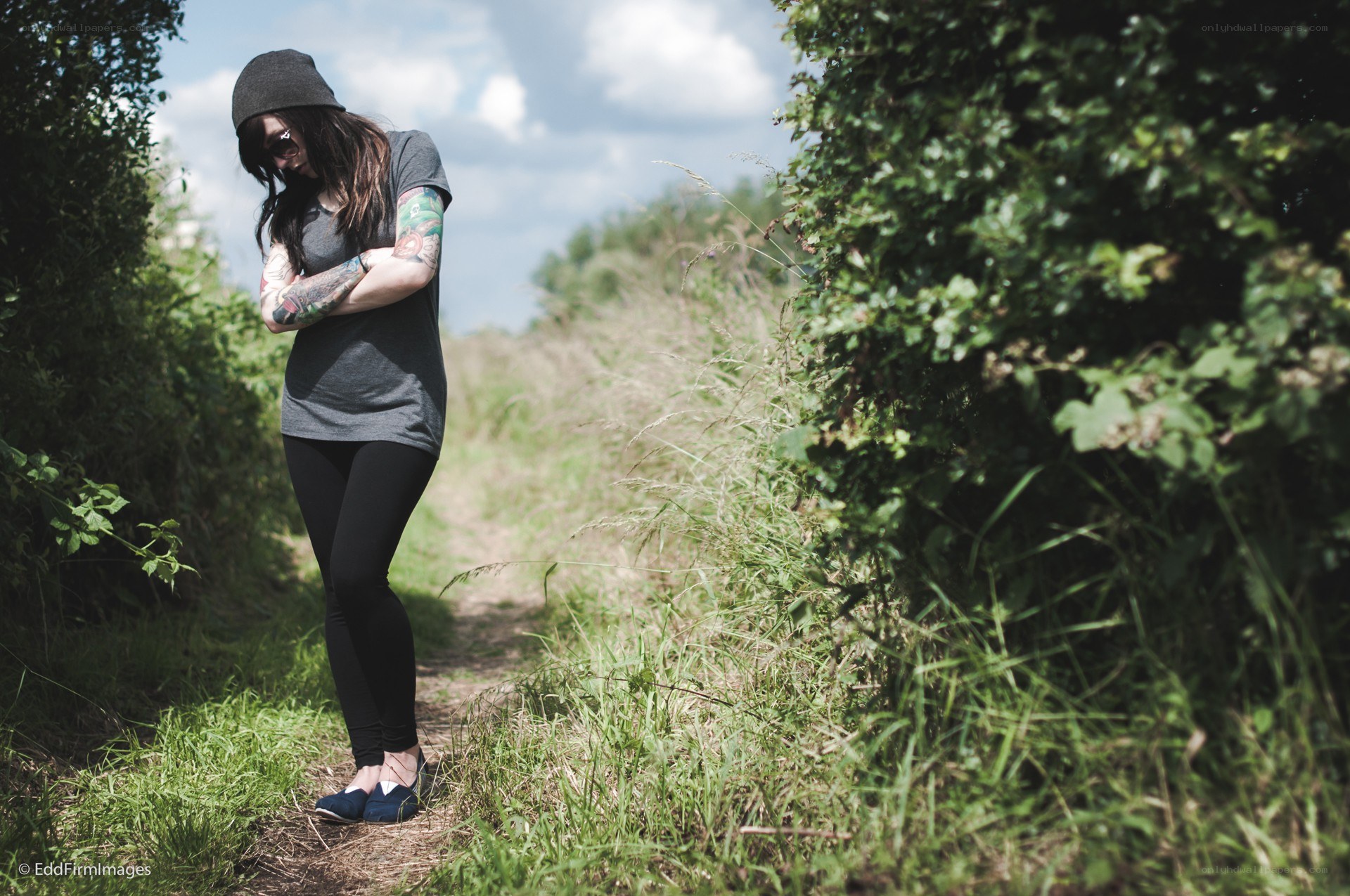 Woman with tattoos on path