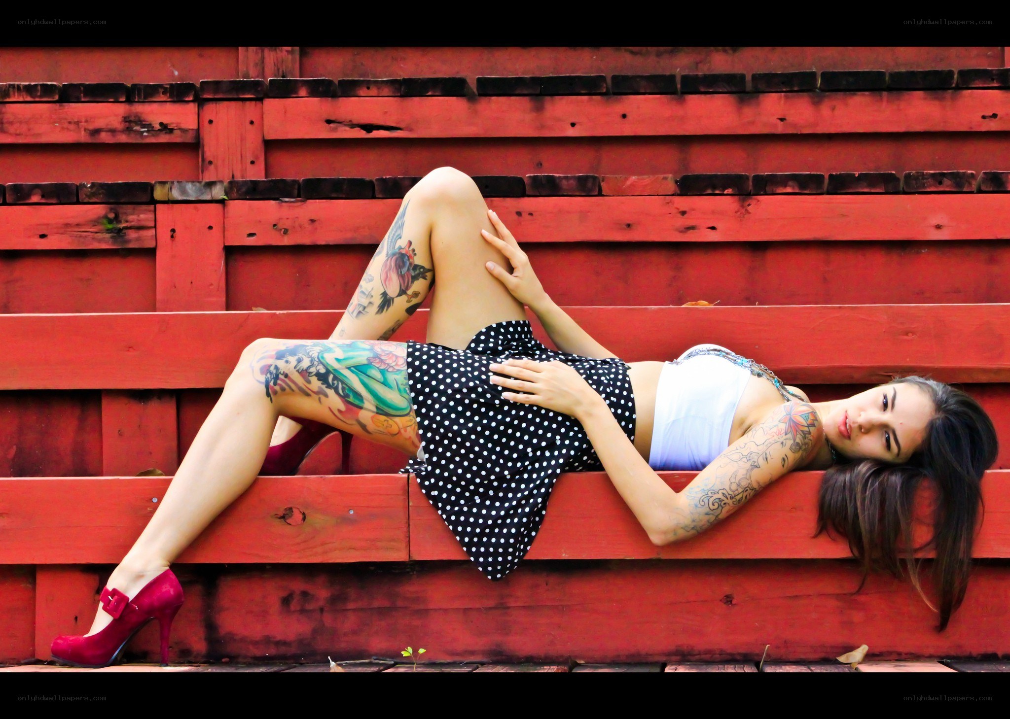 woman with tattoos on red steps