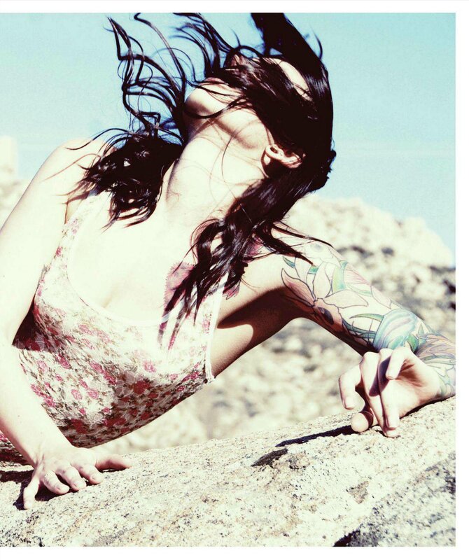 woman with tattoos on rocks