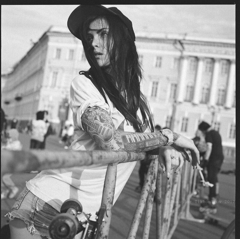 woman with tattoos on skateboard
