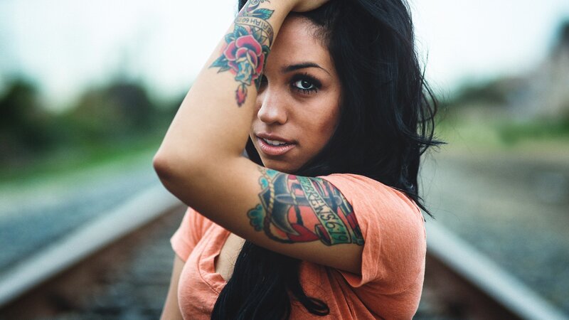 woman with tattoos on train tracks