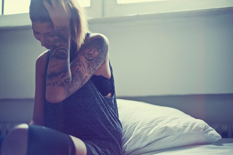 Woman with Tattoos Sitting — Gray, Somber