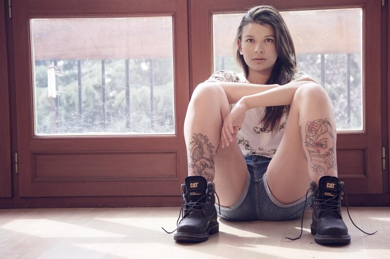 woman with tattoos sitting on floor