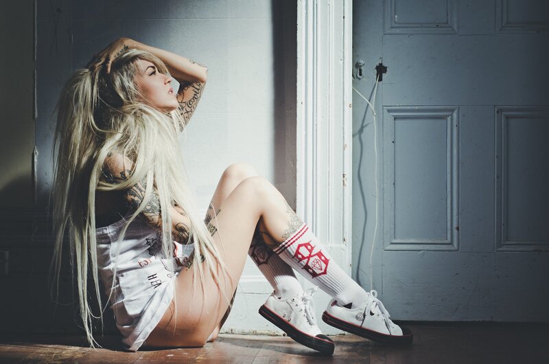 woman with tattoos sitting on floor
