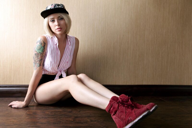 woman with tattoos sitting on floor