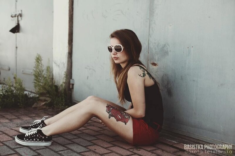 woman with tattoos sitting on ground