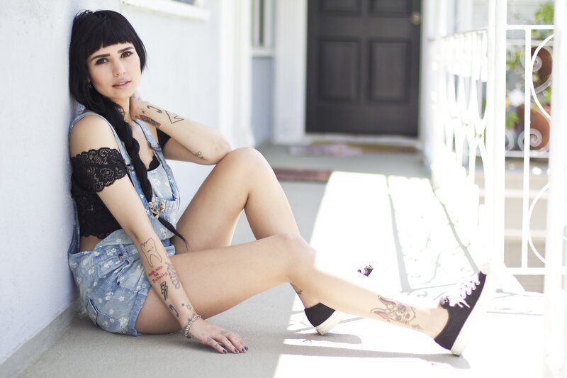 woman with tattoos sitting on porch