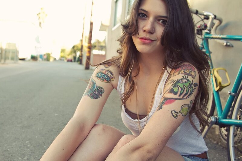 woman with tattoos sitting on street