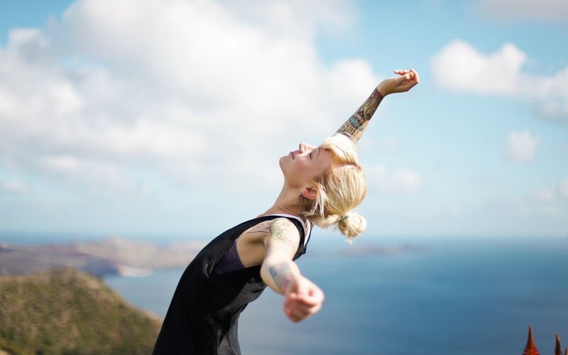 woman with tattoos stretching outdoors