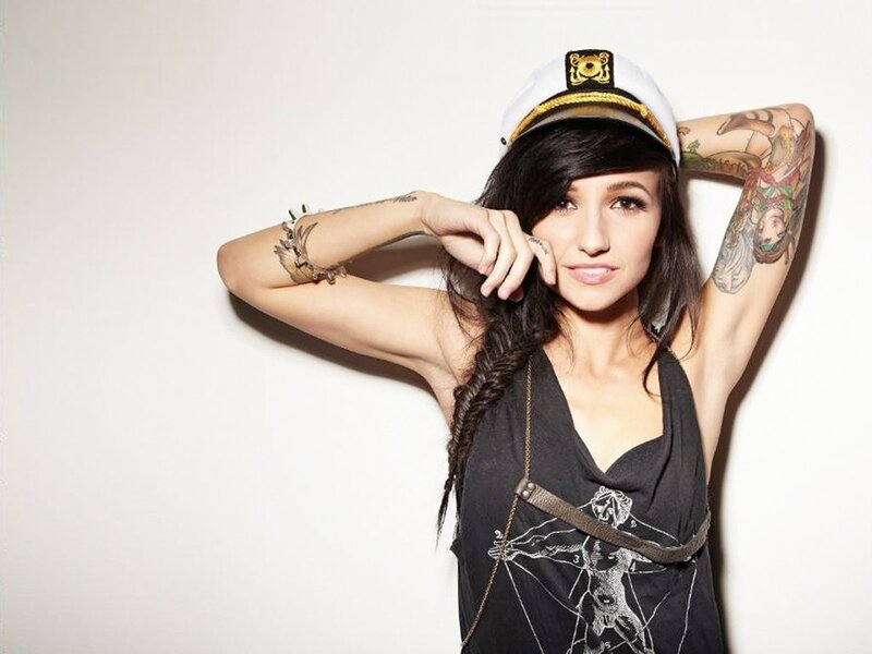 woman with tattoos wearing captain hat