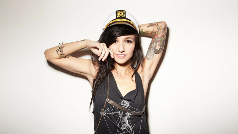 woman with tattoos wearing captain hat