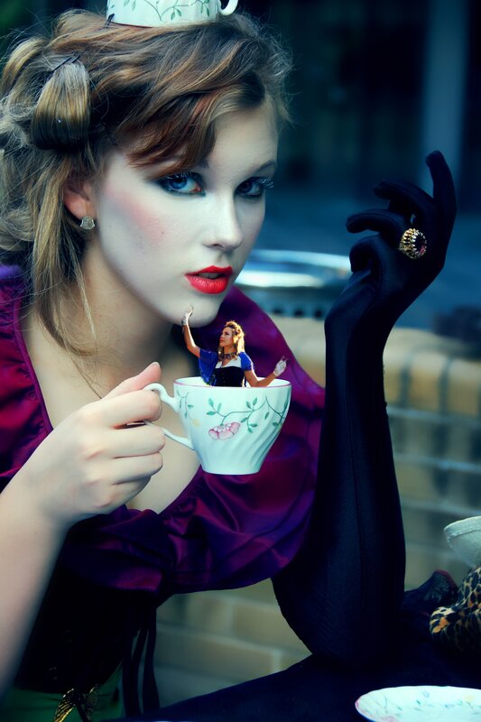 woman with tea cup and miniature figure