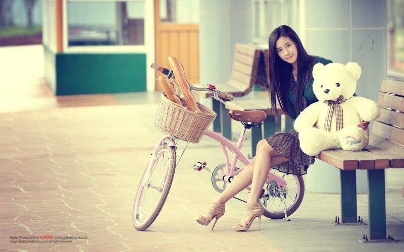 woman with teddy bear and bicycle