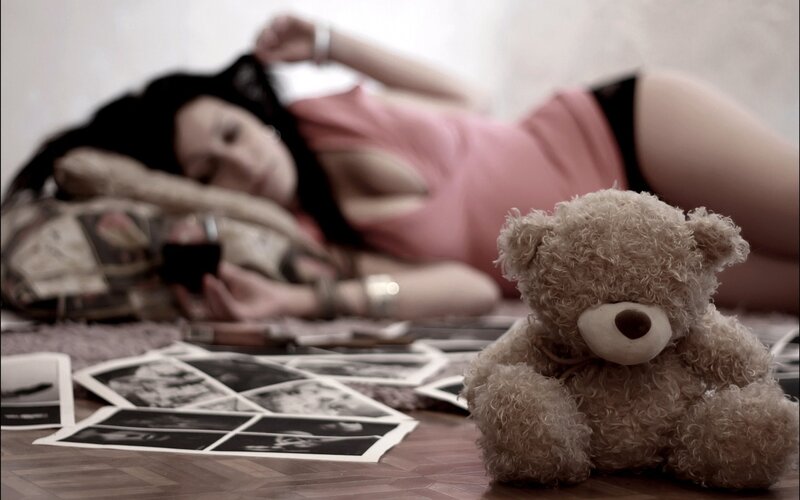 woman with teddy bear and photos