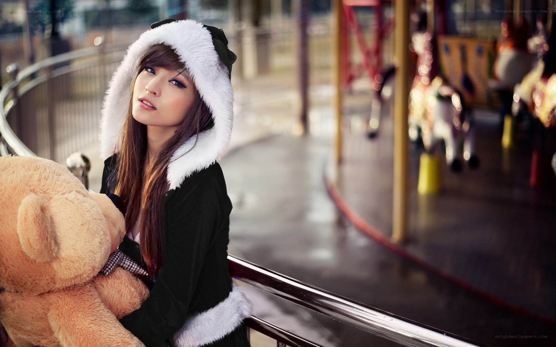 woman with teddy bear at carousel
