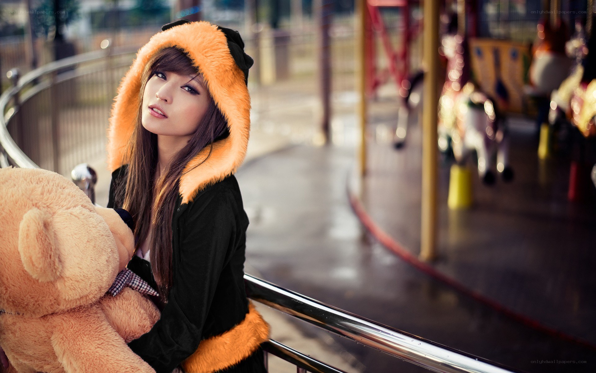 woman with teddy bear at carousel