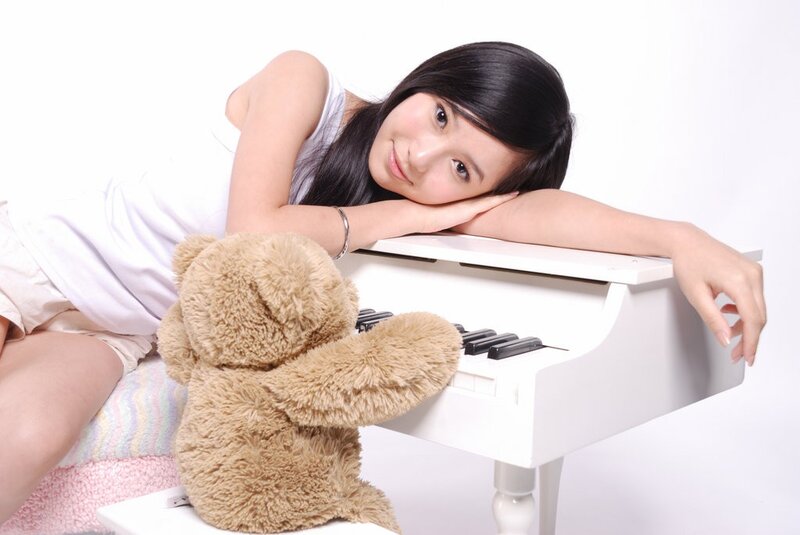 woman with teddy bear at piano