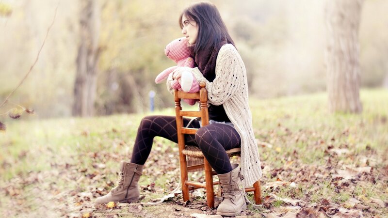 woman with teddy bear in park