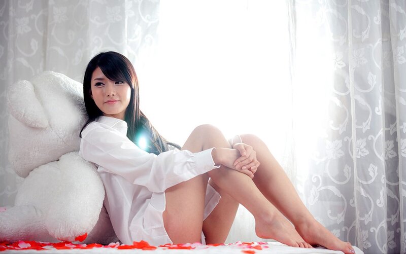woman with teddy bear on bed