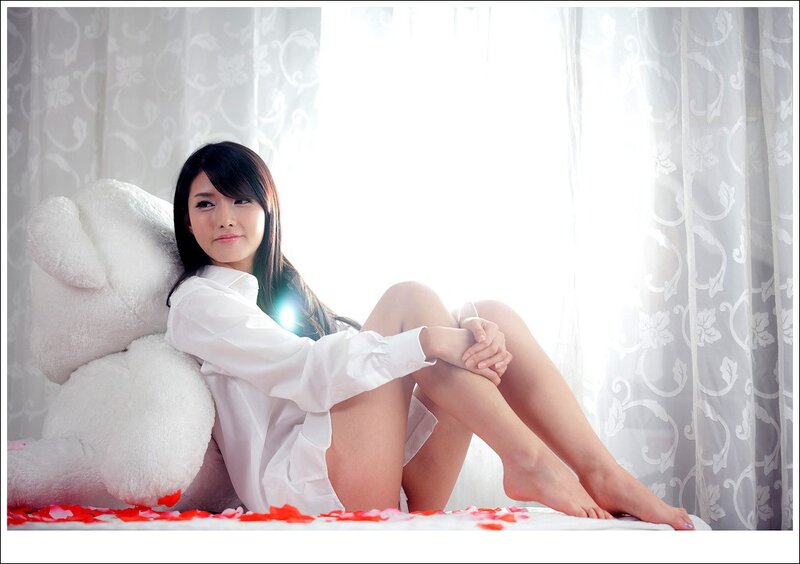 woman with teddy bear on bed
