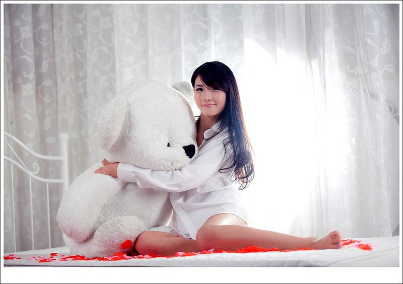 woman with teddy bear on bed
