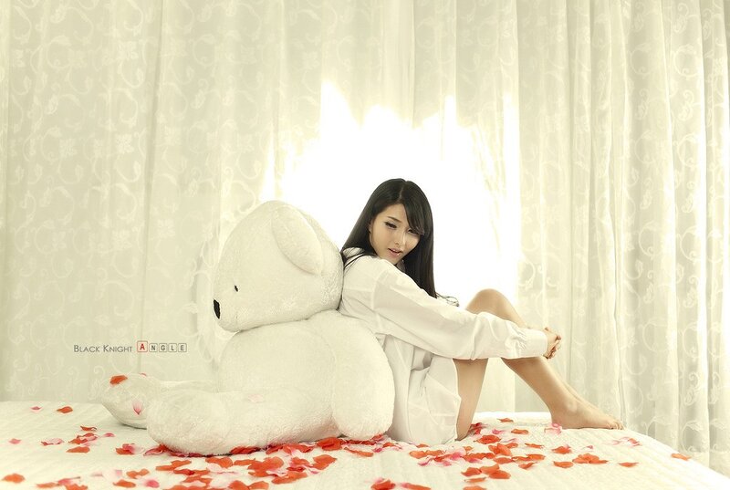 woman with teddy bear on bed