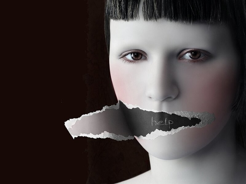 woman with torn paper over mouth