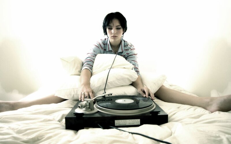 woman with turntable on bed