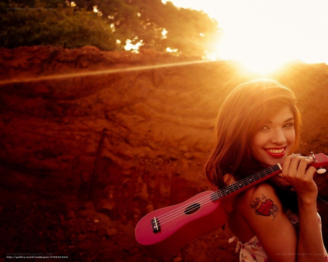 Woman with ukulele at sunset