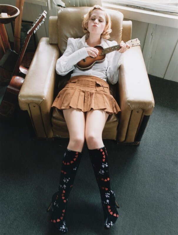Woman with ukulele in armchair